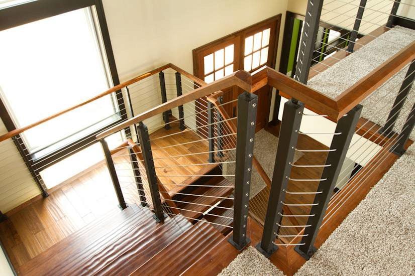 Custom cable railing system with metal posts and wood handrails