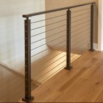 Balcony rod railing with black surface mount posts and handrail